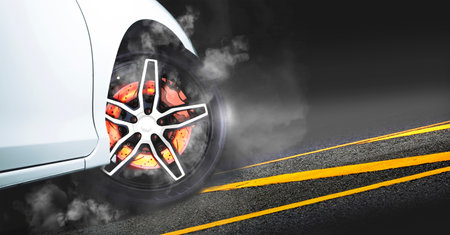 Disc brakes burn with high temperature and the smoke of racing cars on the racetrack at nightの写真素材