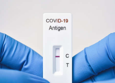 Medical personnel showing Covid-19 negative test result of the antigen rapid test kit on white backgroundの写真素材