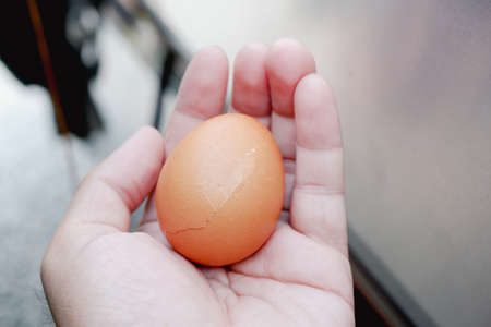 Shattered egg in the hand with a blurred background