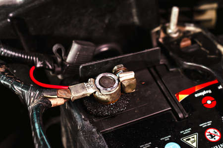 The positive terminal of the car battery with the connection wires of the vehicle electrical system