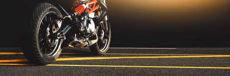 Motorcycle parked alone on a asphalt road in the night time,horizontal copy space,Motorbike panoramic banner conceptの写真素材