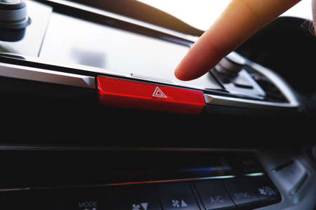 Pressing the emergency light button with the driver hand in the car