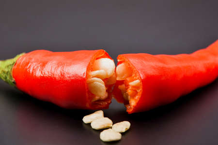 Close up of macro half broken red hot chilli peppers and chilli seeds freshness