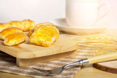 Crispy garlic bread with sugar on wooden table and morning light