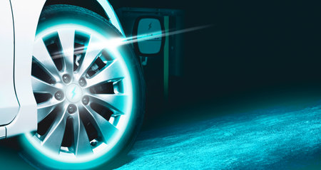 EV electric vehicle parked with a blue neon light on the wheels, Alternative energy concept with copy spaceの写真素材