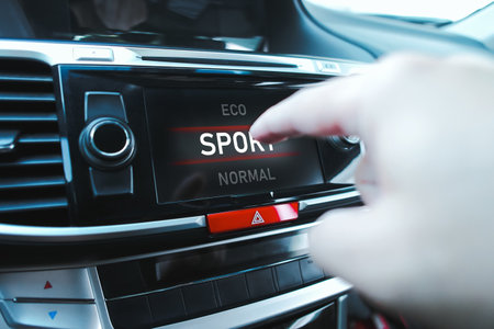The driver is manually selecting a drive mode on a touch screen display in a car.