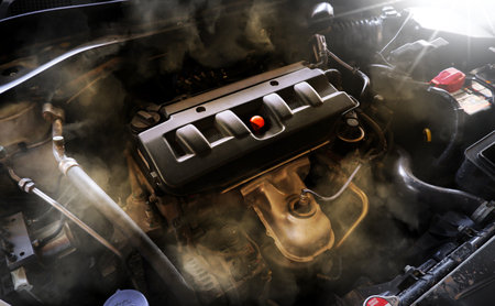 Closeup of a broken car engine with smoke coming out of the engine compartment. Car maintenance service concept.の写真素材