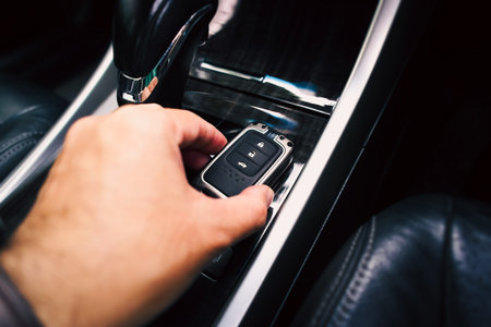 Close up of a driver hand holding a remote control of a car, car keyless entry remote on the auto...