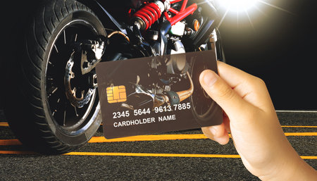 Credit or debit card privilege for motorbike, Hand holding a luxury credit or debit card with a...