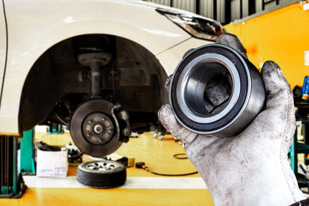 Mechanic holding wheel bearing in automotive workshop , Replacing the front wheel bearings of a car...