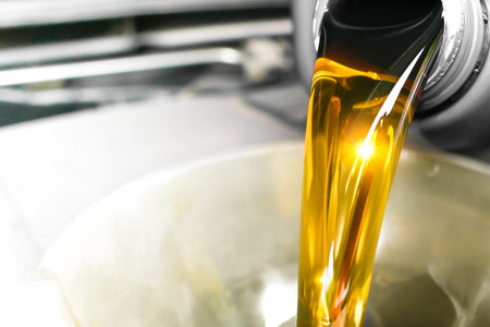 Pouring engine oil into a container , Close up of high quality engine oil being added to a car engine , Car maintenance conceptの写真素材