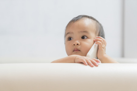 Baby play role talking to a cell phoneの写真素材