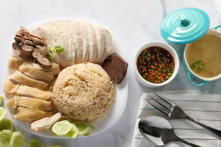 Top view Steamed chicken rice with chilli sauce and soup on white table background. Asia foods...