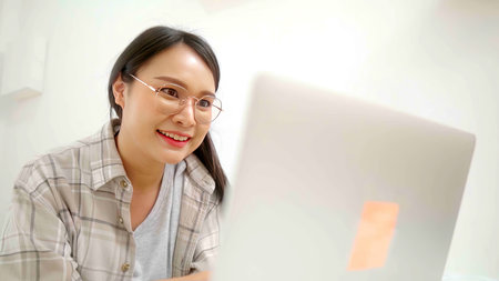 Asian freelance business woman using laptop online business  in bed at home.の写真素材