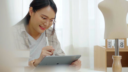 Women designer look to the puppet and use tablet write the details to her work. Startup fashion designer concept.の写真素材