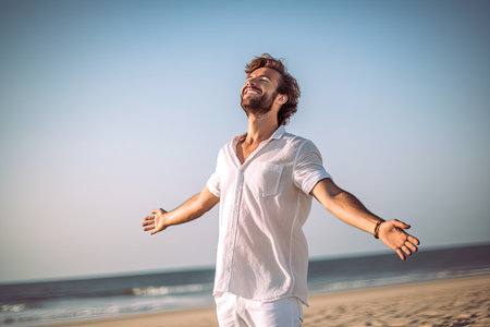 A man with arms out, eyes shut. he wind and breathing fresh air on the beach , Generative AI.の素材