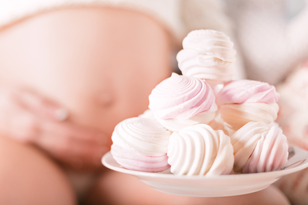pregnant woman waiting to eat sweets marshmallowの写真素材