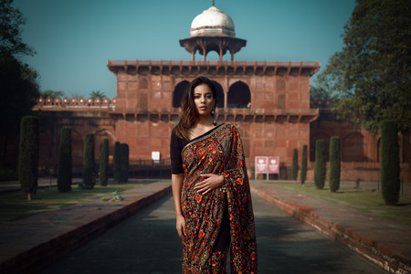 beautiful dark indian girl in front of tombの写真素材