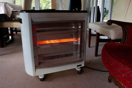 An electric heater with three orange lines. Heating with electricity is the least efficient way of heating.の写真素材