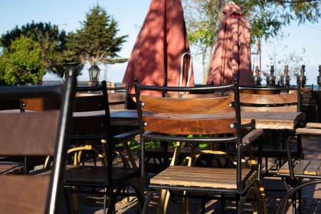 Iron and wooden material mixed chairs in a touristic location with umbrellas.の写真素材