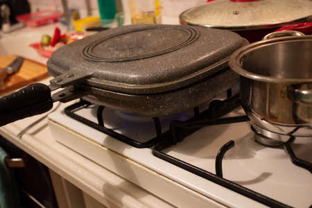 Rectangular granite cooking pan on a cooking stovetop.