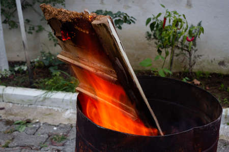 Huge burning wooden pieces in a barrel. Sparkling fireの写真素材