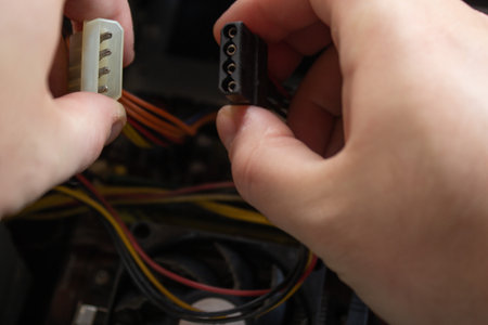 Man hand holding a molex male and female ends of sockets and connecting them into one piece to make...