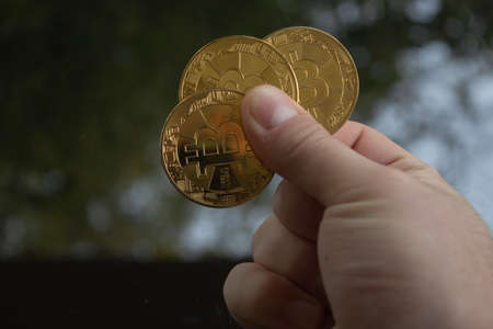 Man hand holding some bitcoin in different variations. Bitcoin is the most valuable currency on the earth for now.の写真素材