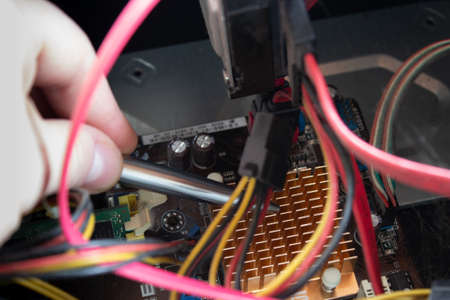 Man hand pointing out some computer pieces in a old dusty and dirty family computer.
