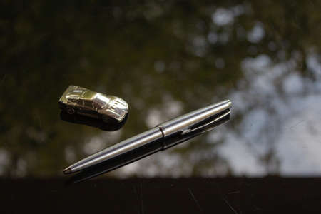 A shiny silver pen on a black surface.の写真素材
