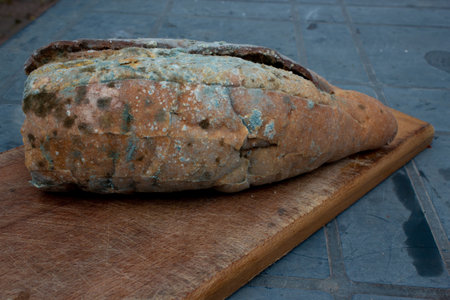 Mouldy bread on a wooden cutting board. Selective focus