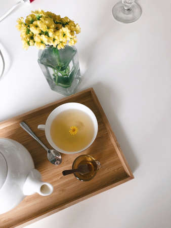Tea pot on a wooden cutting board with tea leaves and other spices and lemon. Healthy drink.の写真素材