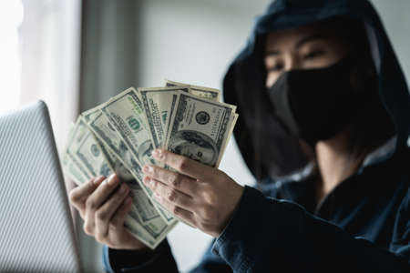 Woman dangerous Hooded Hacker held the money after successfully hacking.