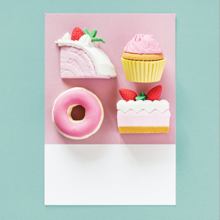 Flay lay of fake cake, cupcake, doughnut and pastry on a spaced cardboard frame