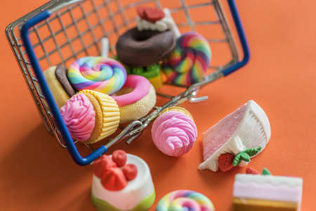 Close up of fake sweets and candies fallen out of a steel wire basket