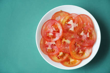 Close up of tomato slices on white plateの写真素材