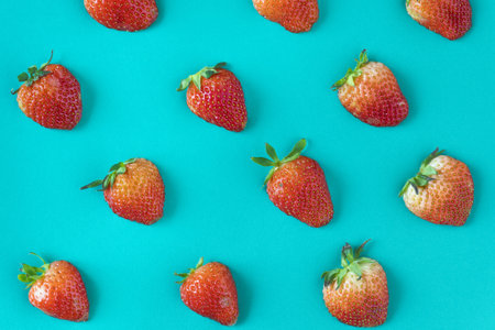 Flay lay of strawberries on greenish blue surfaceの写真素材