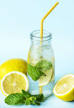 Close up of chilled lemonade in a bottle with yellow straw