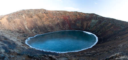 A crater full of dark blue water at the top of mountainの写真素材