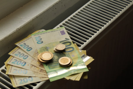 Money on a heating radiator showing expensive heating costs for winter. Hard winter for the whole world. high quality photoの写真素材