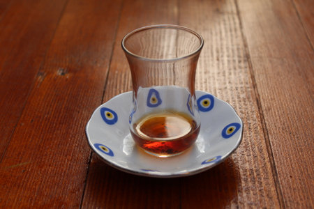 Traditional Turkish black tea in a tiny cup on a wooden table. high quality photo
