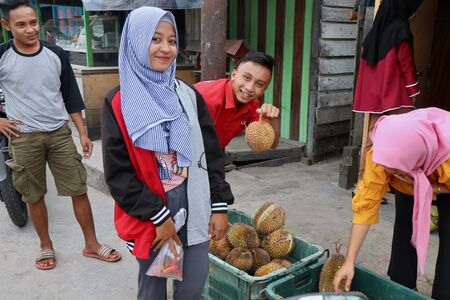 A group of people advertising durians at a fruit stand in Borneoのeditorial素材