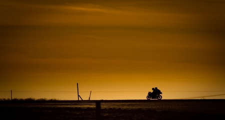 Motor bike in on a road in the sunsetの写真素材