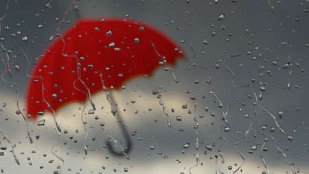 Umbrella behind rainy windowの写真素材