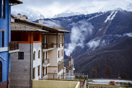 View of a house from a frame with snow mountain  falling during winter