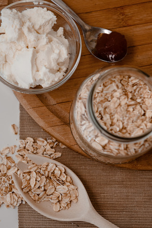 Fresh cherry, oats and yoghurt in  cup on kitchen towel pebbles in the backgroundの写真素材