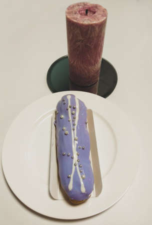 Delicious cake with purple icing and decorated with silver beads from sugar.