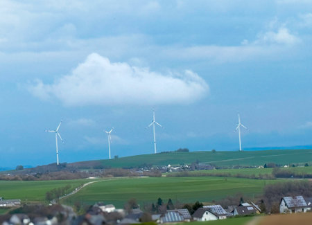 Wind turbines on beautiful sunny summer mountain landscape. Curvy road through mountain wind park....