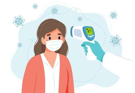 Body temperature check, woman is being checked with infrared thermometer.