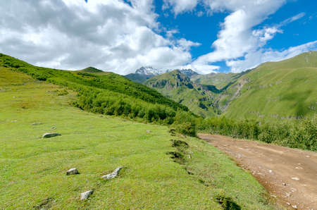 Road to mountains and beautiful clouds. Small stones on the way